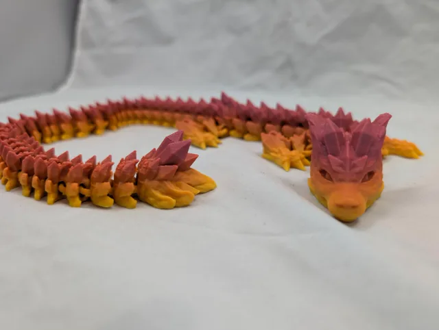 Cloveox, a green 3D-printed dragon with a yellow flower